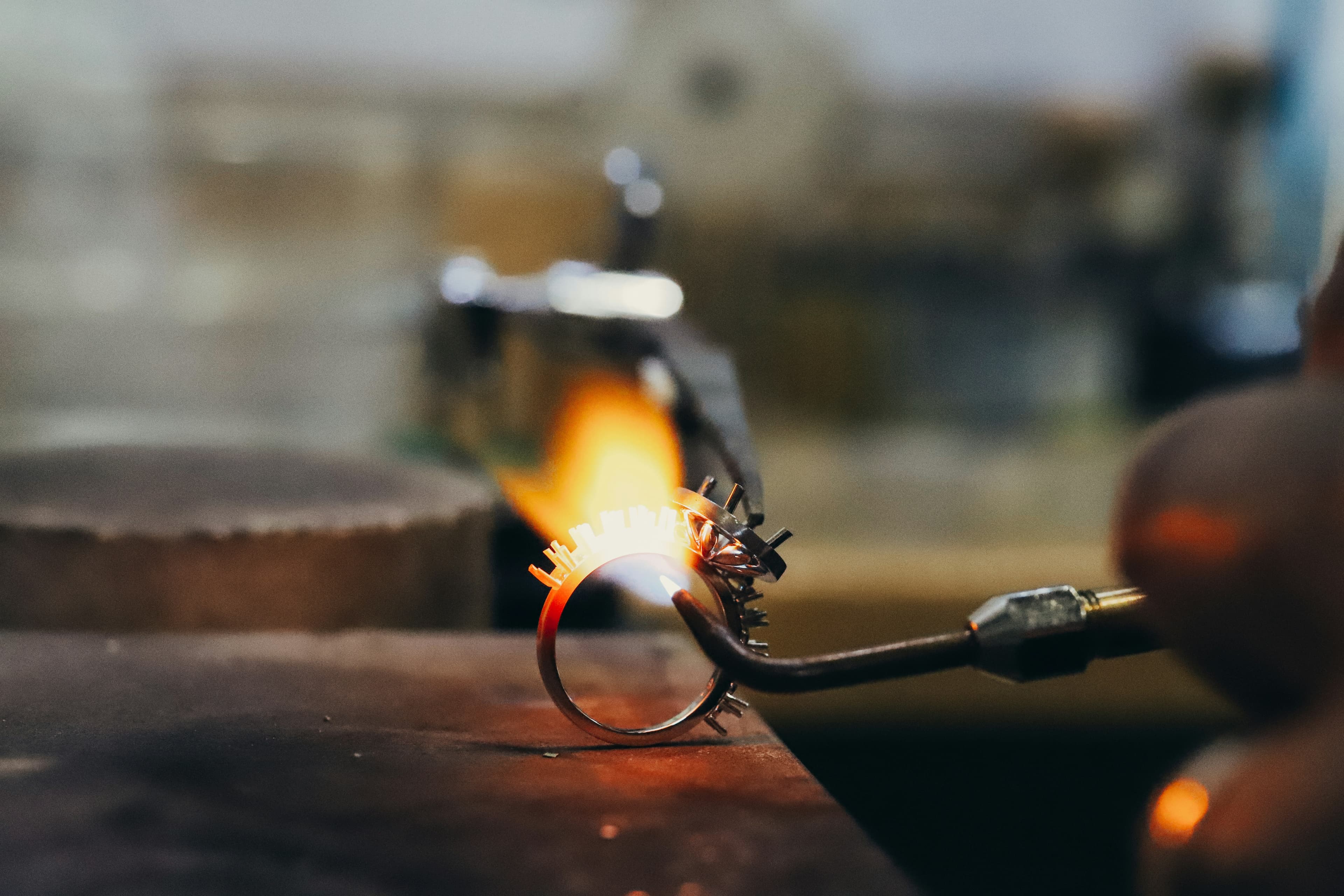 Master jeweler repairing a ring under dramatic workshop lighting